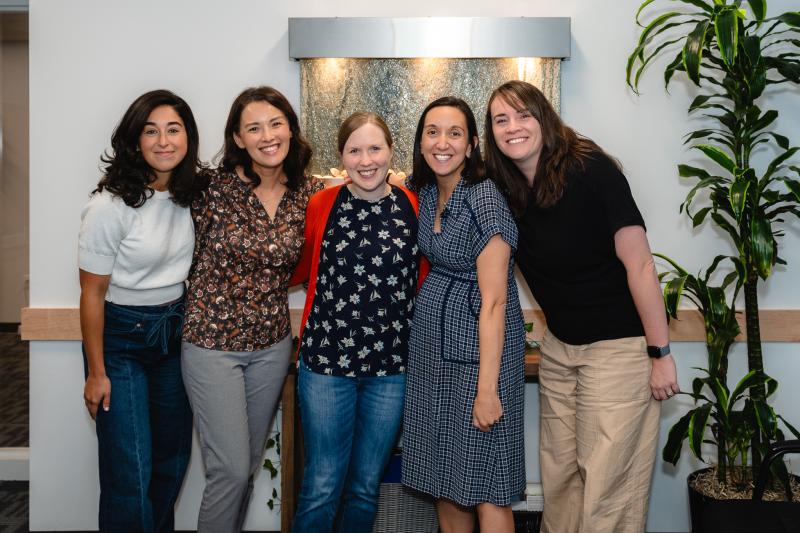 a group of four medical providers in front of a fish tank