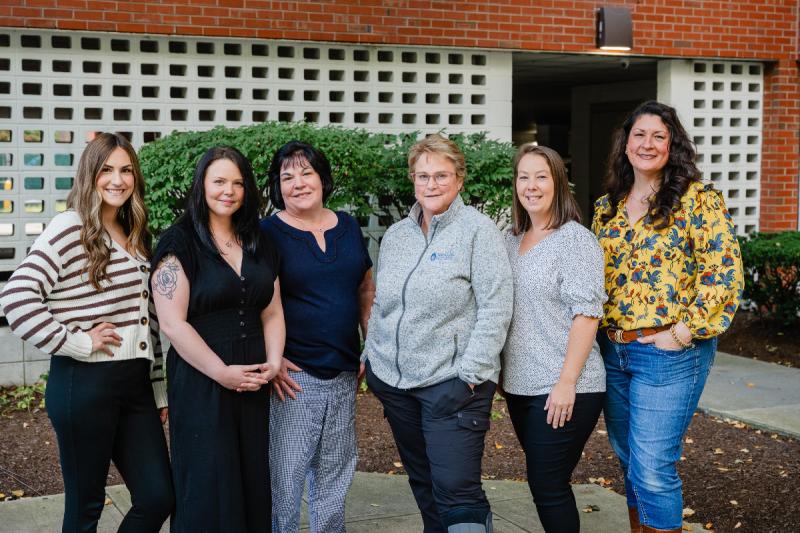 a group of six medically professional women smiling outside